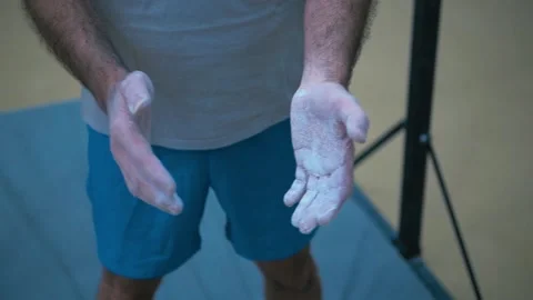 Man in the gym claps his hands soiled with chalk. Stock Footage 149078634