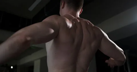 A man in the gym does an exercise by straining his back muscles. Stock Footage 158918390