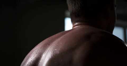 A man in the gym does an exercise by straining his back muscles.  Stock Footage 158922030