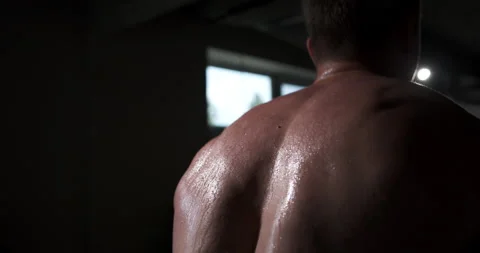 A man in the gym does an exercise by straining his back muscles.  Stock Footage 158922075