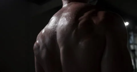 A man in the gym does an exercise by straining his back muscles.  Stock Footage 158922091