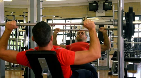 Man at gym doing exercise with barbell Видео 34371100