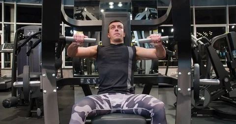 Man in gym doing press push weight exercise 4k video. Chest training on machine Stock Footage 71800164
