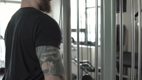 Man in gym doing pulls weight on cable machine close-up 4k. Stock Footage 85716087
