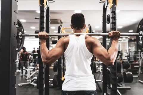Man at the gym. Execute exercise squatting with weight, in gym Foto stock