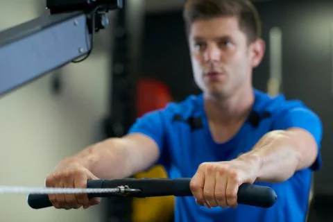 Man In Gym Exercising On Rowing Machine Stock Photos