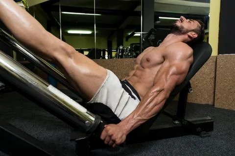 Man In Gym On Machine Exercising Stock Photos