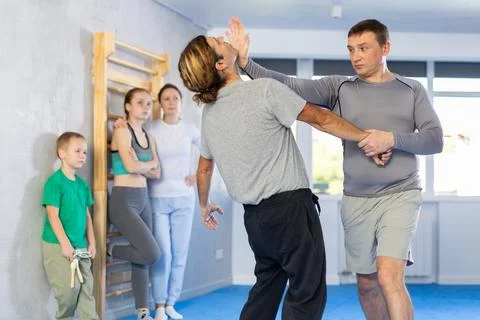 Man in gym perform basic elements of krav maga self-defense system. Stock Photos