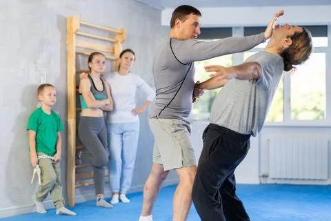 Man in gym perform basic elements of krav maga self-defense system. Stock Photos
