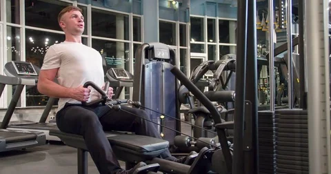 Man in gym pulls weight exercise 4k video. Training back muscles cable machine Stock Footage 71798928
