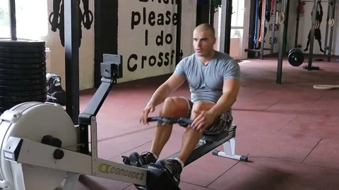 Man in gym working out on a rowing machine Stock Footage 83513373