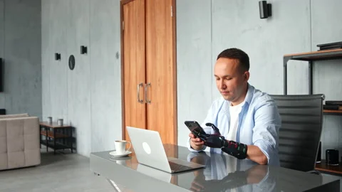 Man hacker with black bio hand prothesis types on smartphone Stock Footage 157330514