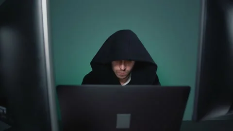 Man hacker in black hood working with several computers Stock Footage 159558470