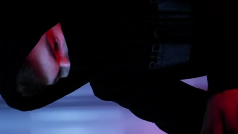 Man hacker face in black mask and hood looking at computer screen.Vertical video Stock Footage 255252698