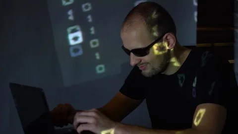 A man hacker in sunglasses in a dark room works with the program code. concept 스톡 동영상 107381997