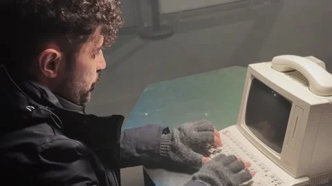 Man Hacker Typing on Vintage Computer with Retro Phone Stock Footage 346184033