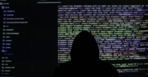 Man hacker working in dark abstract room. Programming code on a large screen in 库存照片