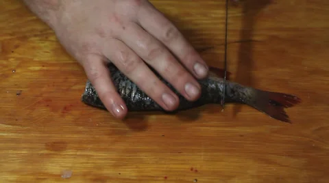 Man hacking a little fish Stock Footage 36005534