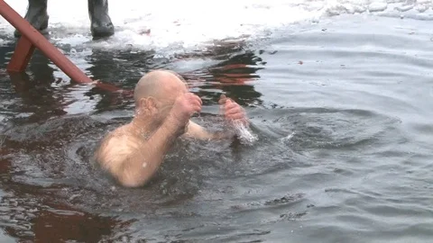 A man with a hairy back is dipped into ice water. Dipping in cold water at a rel Stock-Footage 101283391