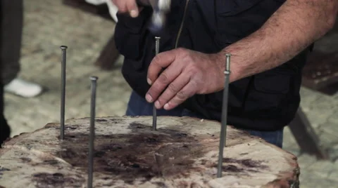 Man Hammering a Big Nail On a Tree Trunk Stock Footage 68497259