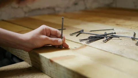 The man is hammering a nail into the board close-up Stock Footage 77211486