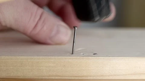 Man is hammering a nail into a wooden board. Stock Footage 344123771