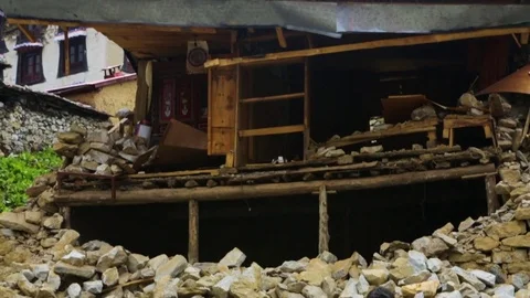 Man hammering rock in front of a demolished house Stock Footage 77449560