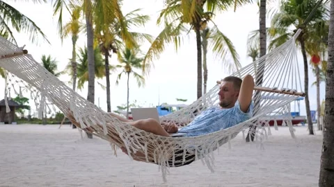 Man in hammock on beach. Close-up: man lies in hammock on beach near ocean Stock Footage 270006871