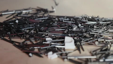 Man hand adds nails to large scattered pile of metallic fasteners Video stock 316158715