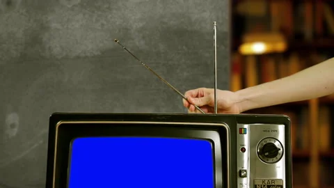 Man Hand adjusting the Antenna of an Old Television with Blue Screen. 4K. Stock Footage 152752592