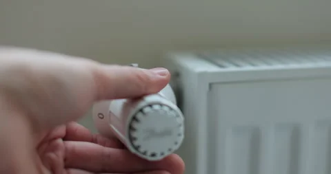 Man hand adjusting temperature on heating radiator. Stock Footage 293350640