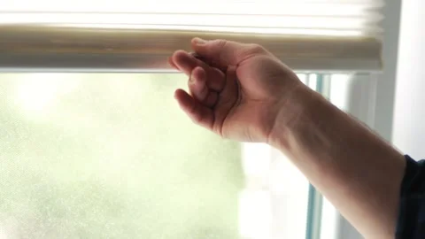 Man hand adjusting white pleated window blinds to control daylight Vídeo Stock 340159643
