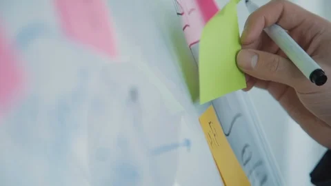 Man hand attaching sticky note to task board in office Vídeos de archivo 119462367
