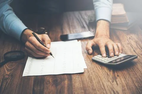 Man hand calculator and documents Stock Photos