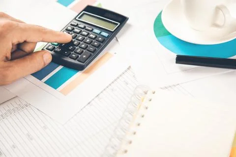 Man hand calculator on document with coffee Stock Photos