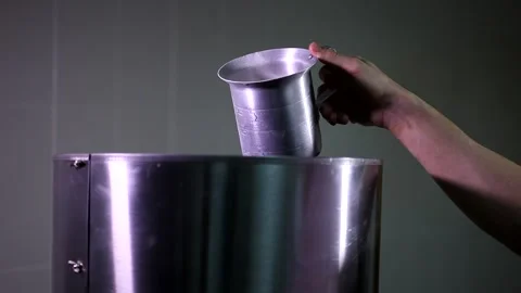 Man hand carefully putting a small amount of brown sugar from cup in automatic p Stock Footage 137541660