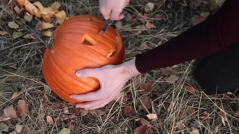 Man hand carving pumpkin head jack lantern at all hallows eve Stock Footage 252325257