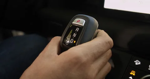 Man hand changes gear selector from Drive to Reverse Video stock 201214572