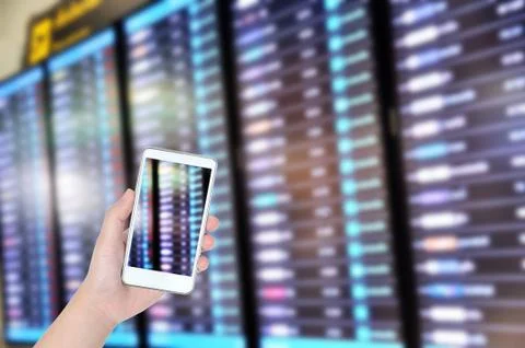 Man hand checking flight with flight board with smart phone, Technology conce Stock Photos