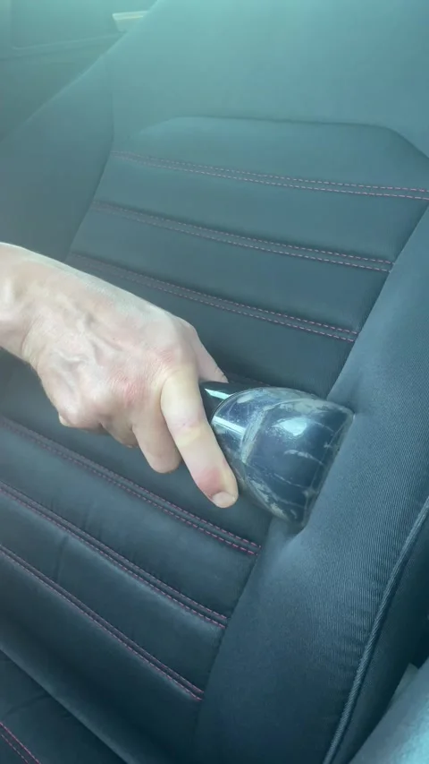 Man hand cleaning black cloth car seat with vacuum extraction nozzle Stock Footage 340778624