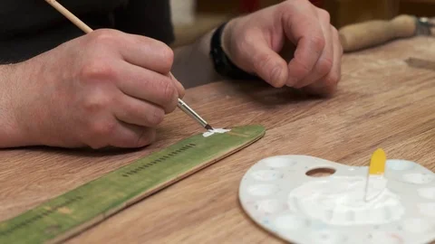 Man hand colours outdated fuselage model in white with brush Stock Footage 127375457