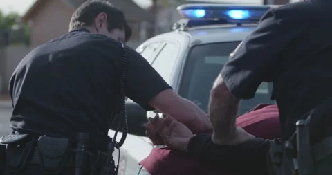 Man In Hand Cuffs Resisting Arrest By Two Police Officers, Being Searched by Cop Stock Footage 247019941