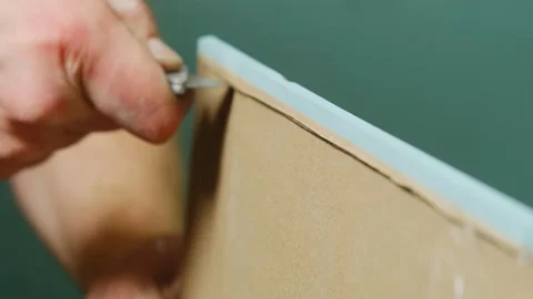 Man hand cuts plasterboard panel using sharp knife in workshop Stock-Footage 304407219