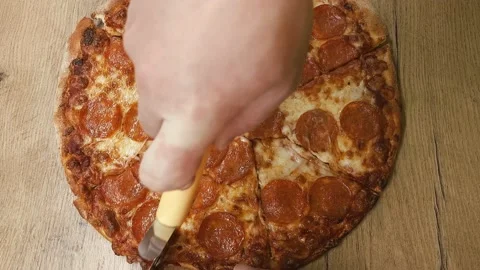 Man hand cutting pizza with a round cutter knife Stock-Footage 235716633