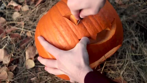 Man hand cutting pumpkin head jack lantern Stock Footage 252325256