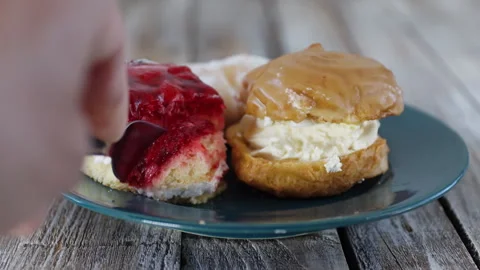 Man hand cutting raspberry jelly cake on plate with fork. Cream puff, cream.. Stock Footage 335945890