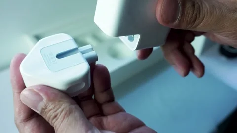 Man Hand Demonstrating How to Assemble Apple Power Adapter Stockbeeldmateriaal 334644950
