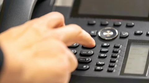 Man hand dialing number on office telephone/landline Stock Footage 122054856