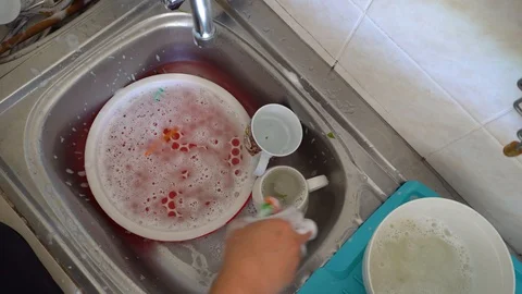 Man hand doing house work washing dishes Rinse a dish by hand in a sink Stock Footage 127582715