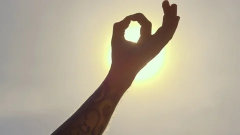 Man hand doing yoga posture against sun Stock Footage 74776433